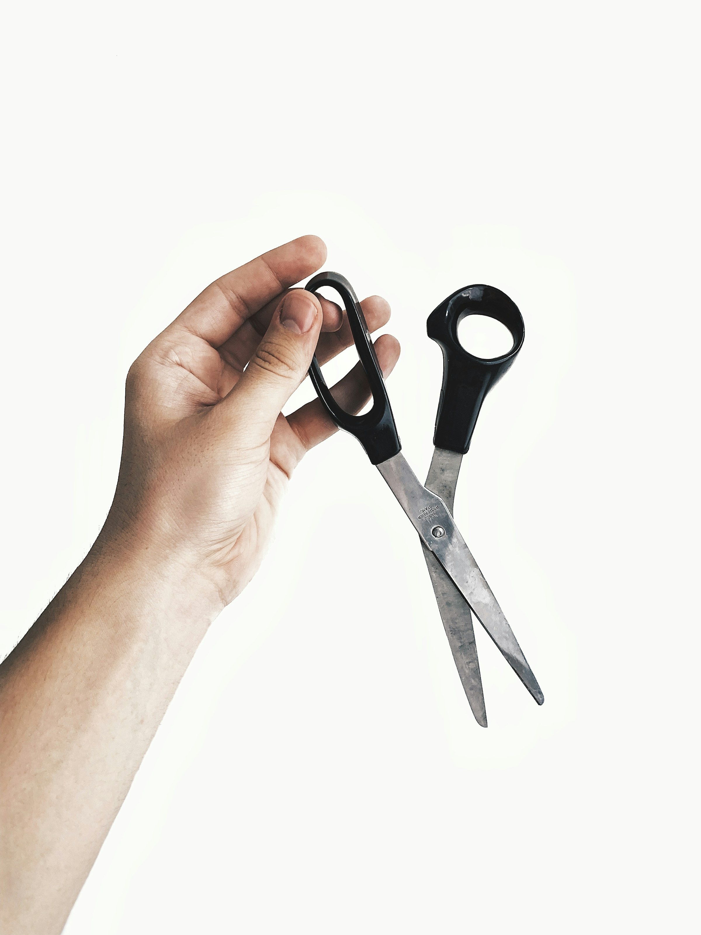 Black handled hairdressing scissors resting on a dark background