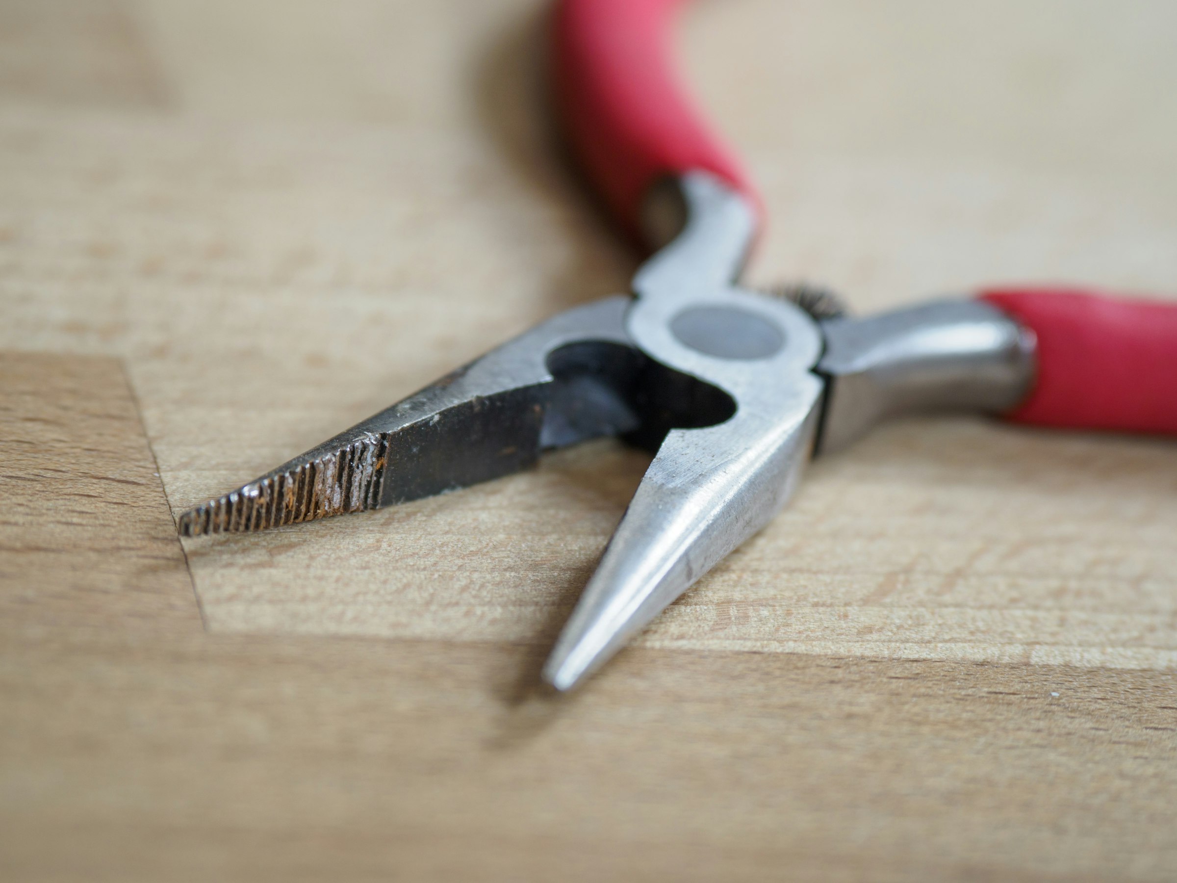 Red-handled barber scissors highlighting the pivot screw