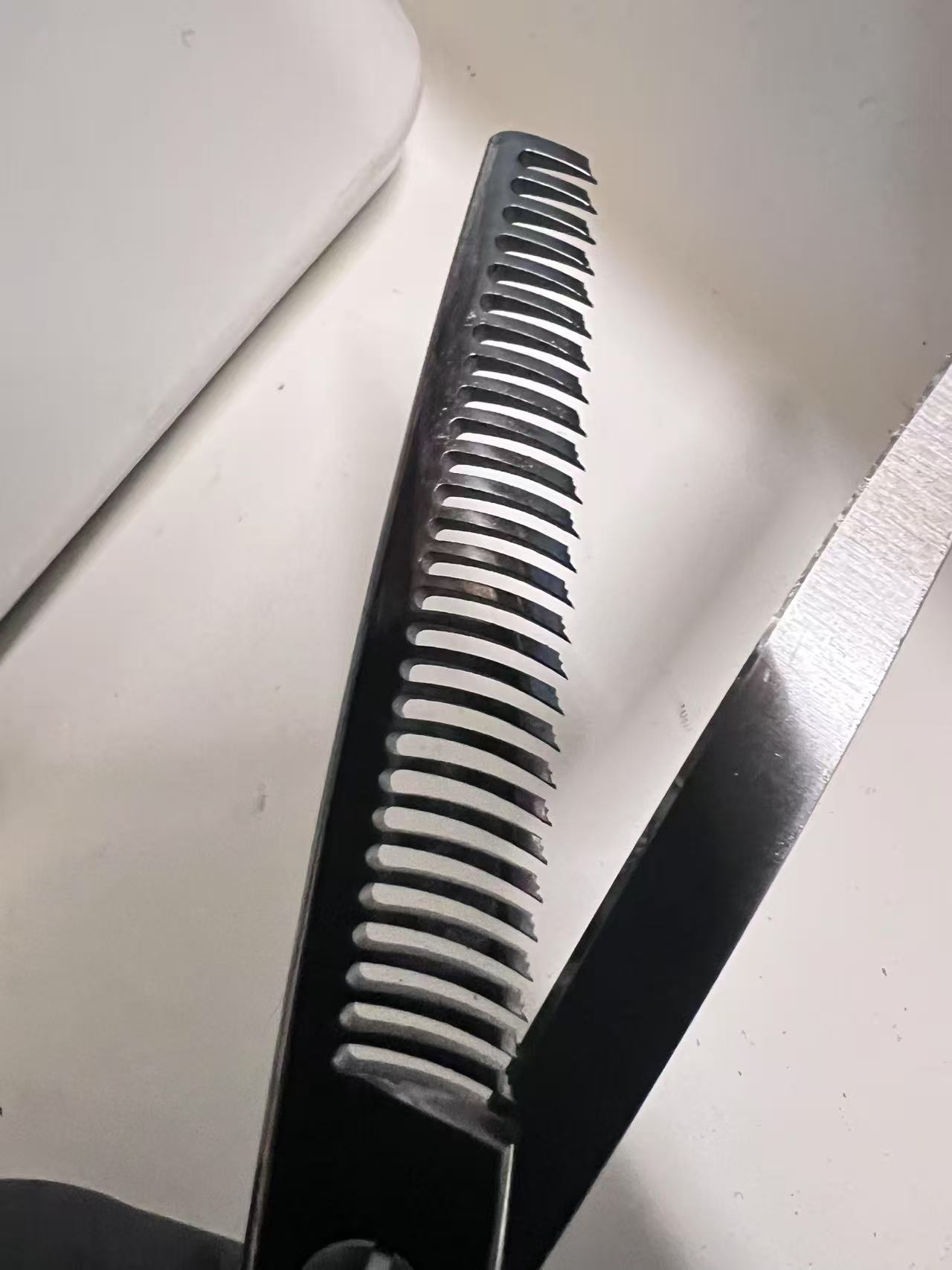 Thinning scissors blade with visible surface marks and inconsistencies