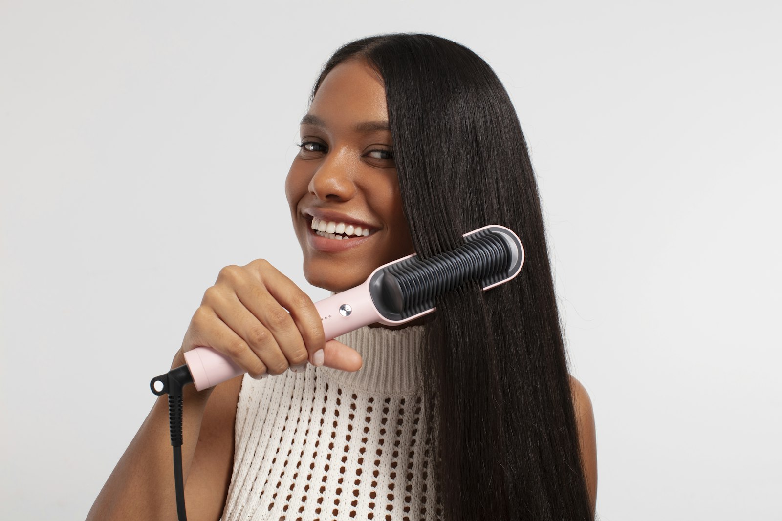 Stylist blow-drying straight hair with a round brush