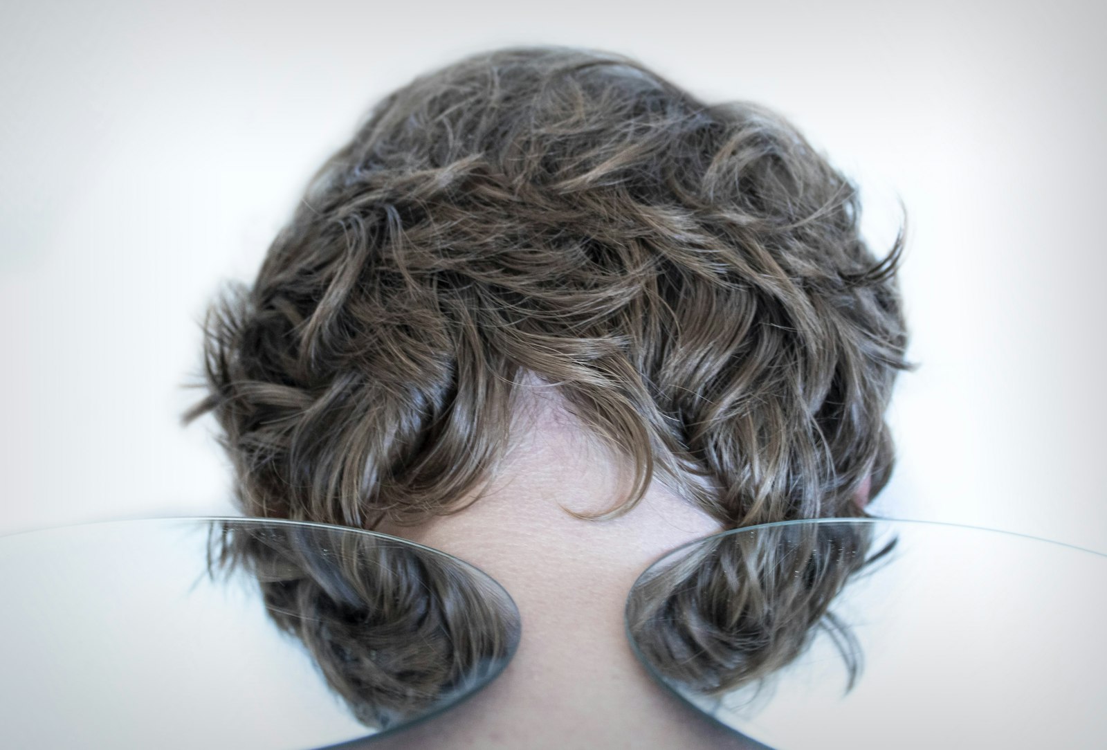 Wavy brunette hair falling across the face