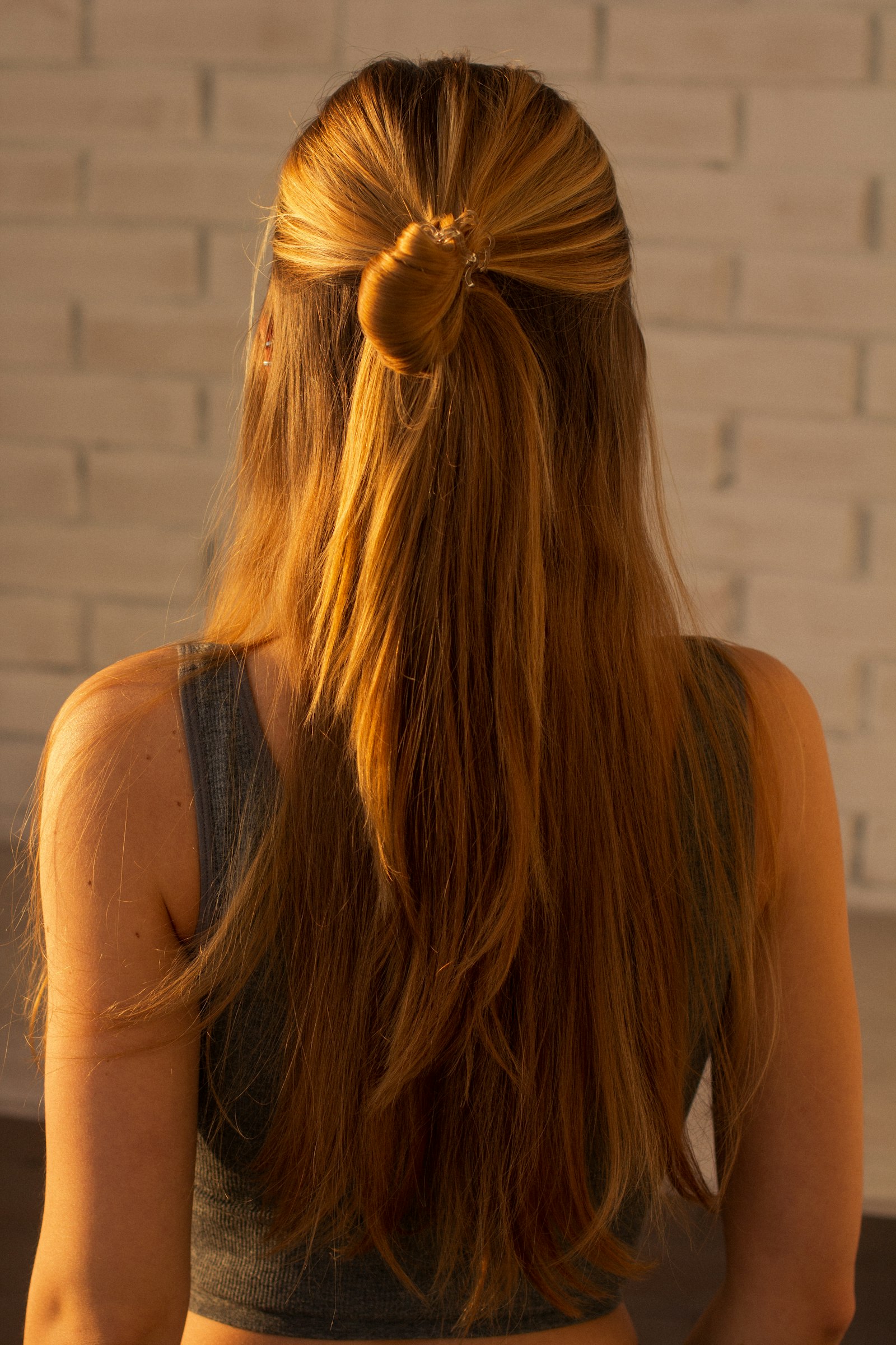 Defined brunette waves framed against a warm backdrop