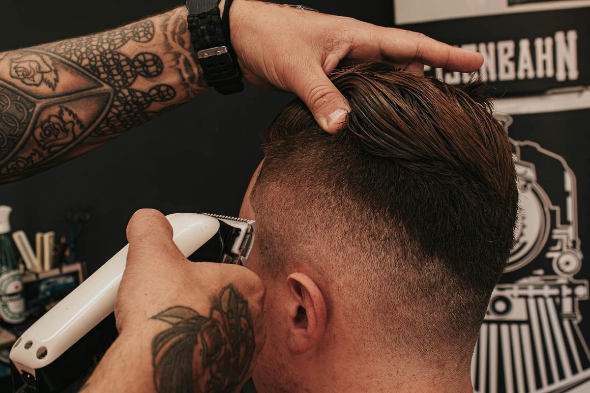 Barber cutting customer hair with focused precision