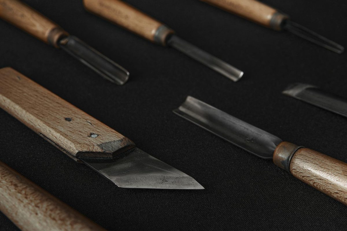 Sharpener inspecting blades under bright workshop lighting