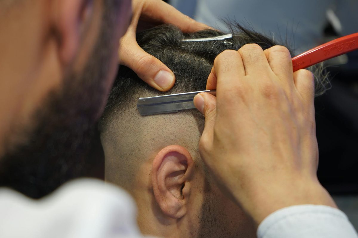 Professional barber cutting hair in contemporary salon