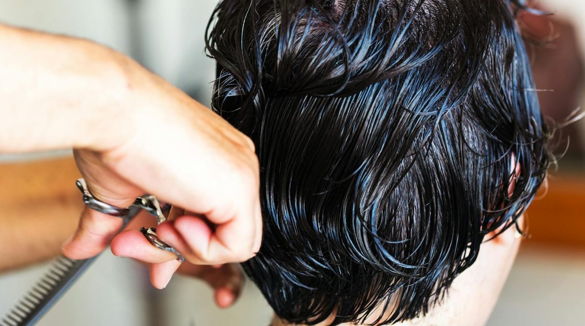 Professional scissors cutting hair in salon environment