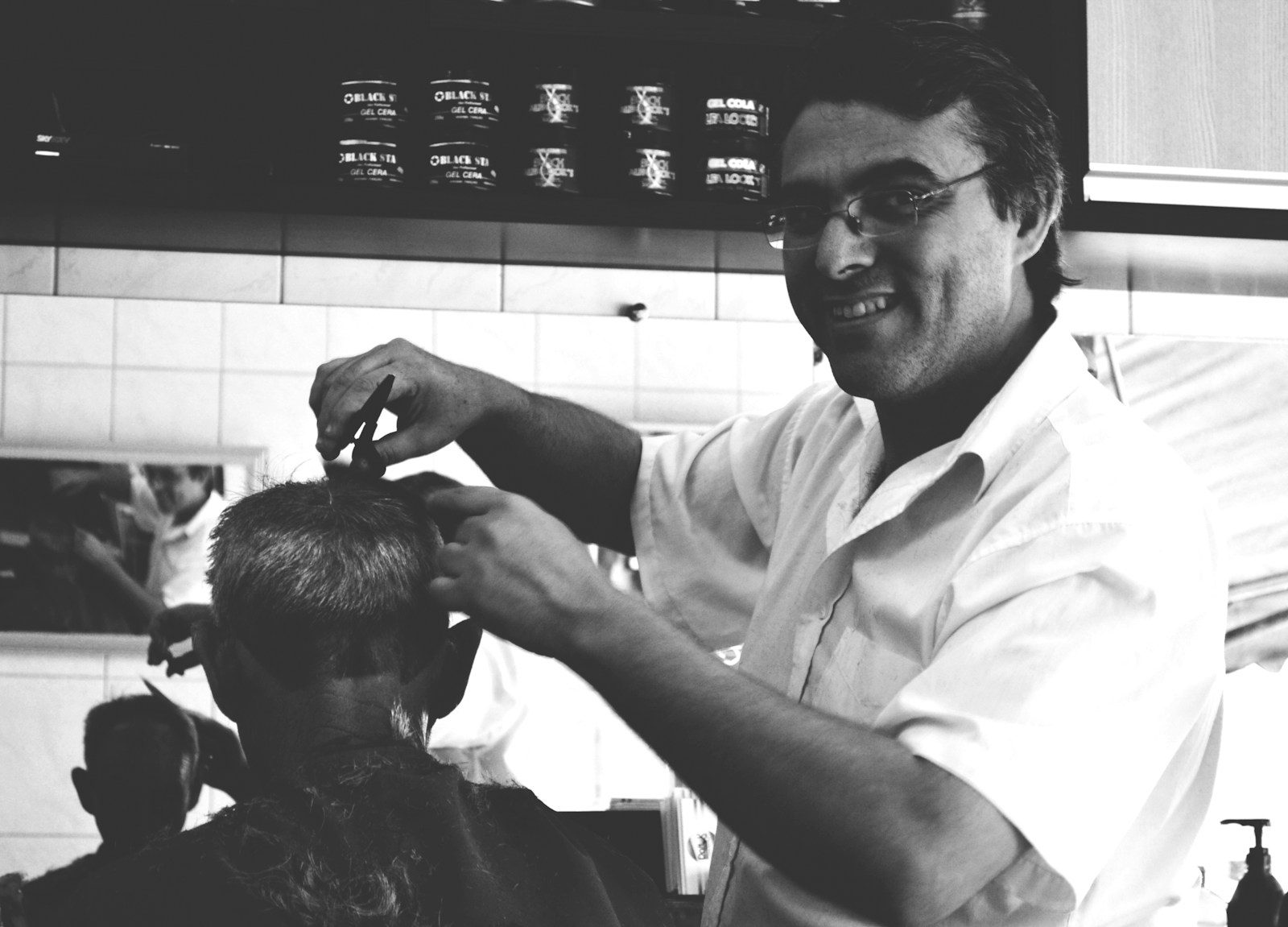 Barber adjusting a client’s fade with shears and comb