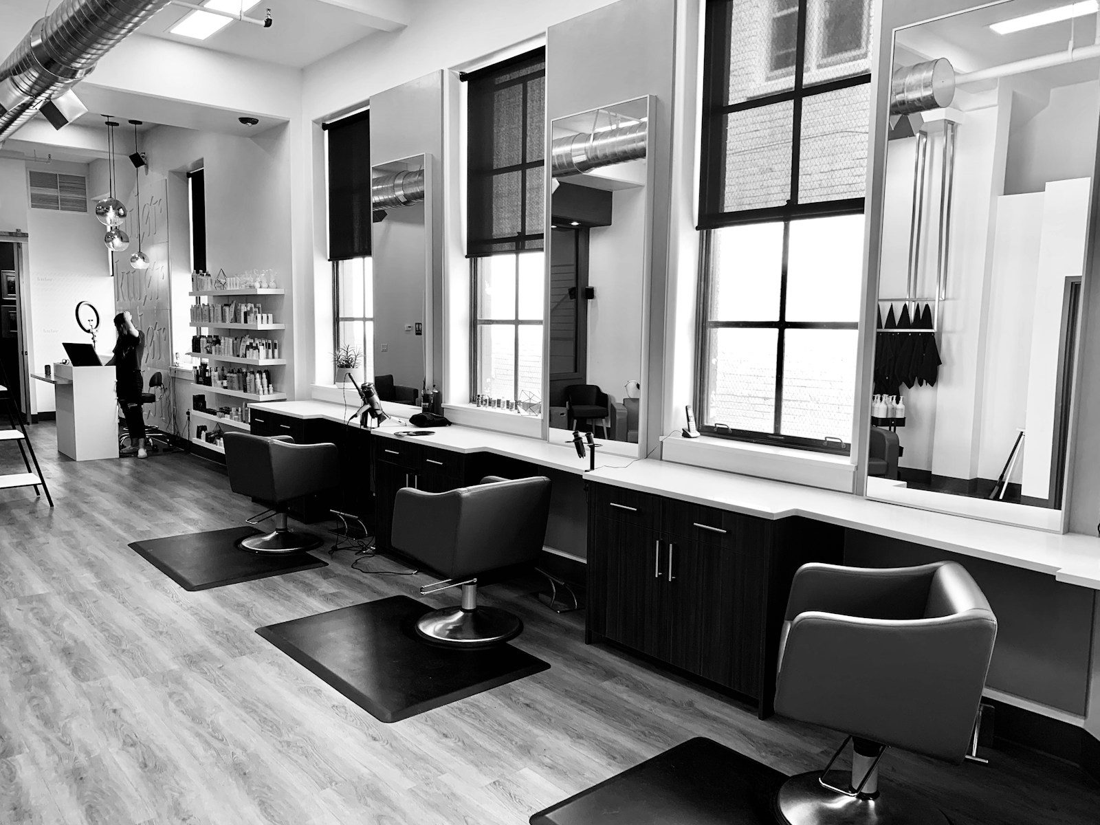 Stylist working on a laptop at a row of salon chairs