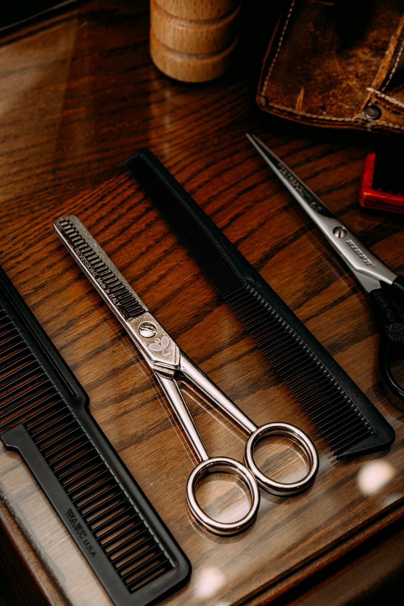 Close-up of professional shears arranged on a wooden tray