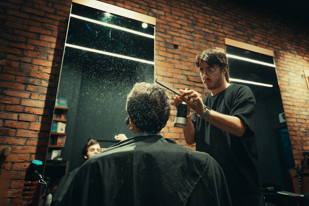 Stylist dry cutting hair while comparing wet section