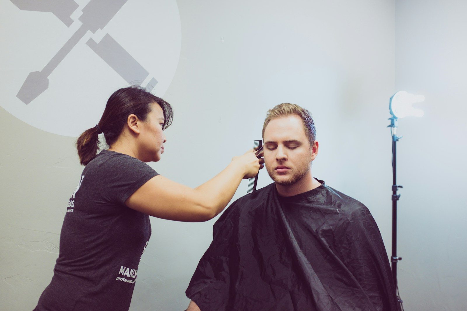 Stylist trimming a male client’s hair at the chair