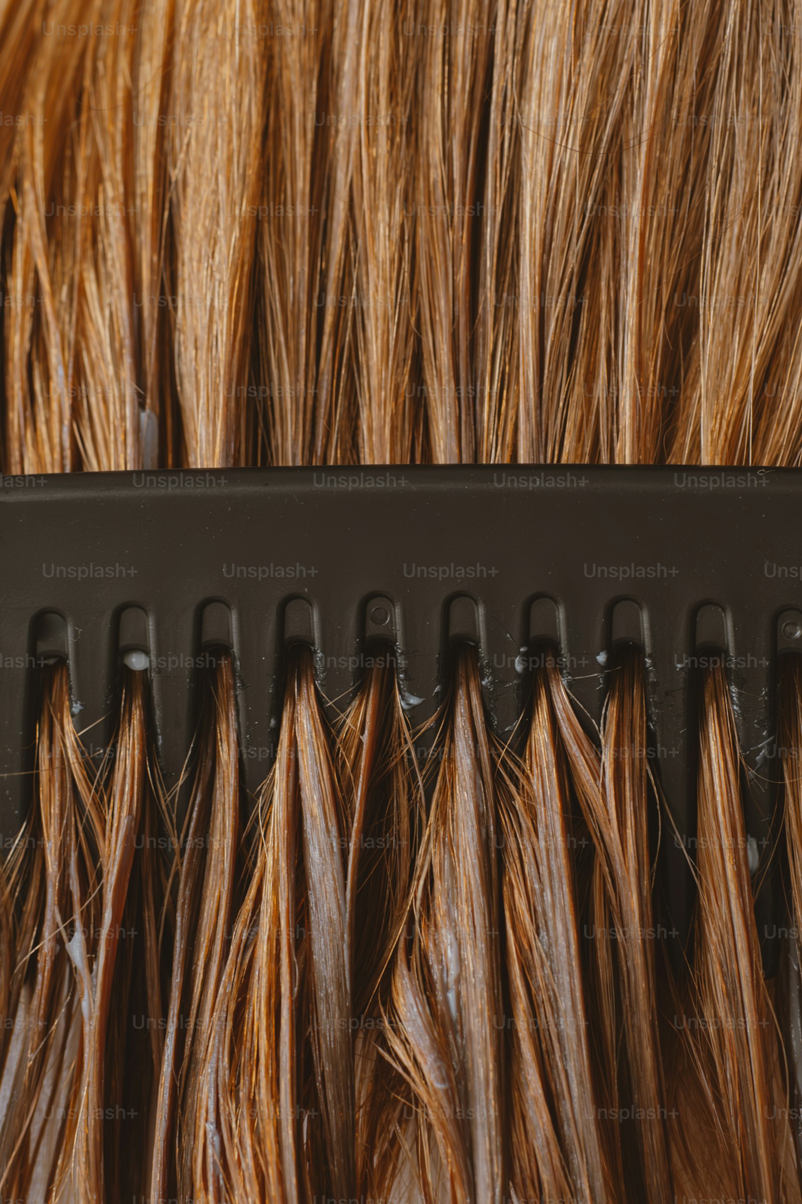 Close-up of comb and brunette hair extensions ready for blending