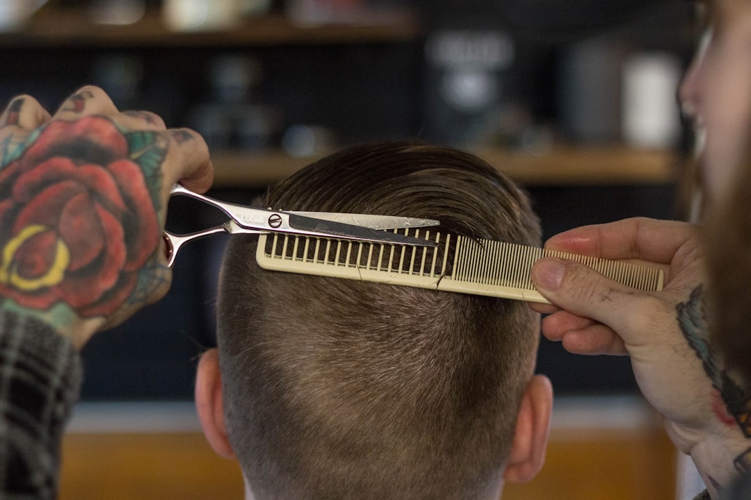 Barber refining a fade with scissor-over-comb technique